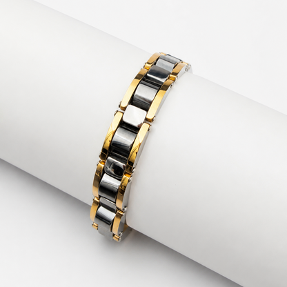 A two-tone metal link bracelet with gold and silver polished bands, displayed on a white cylindrical stand against a light gray background.
