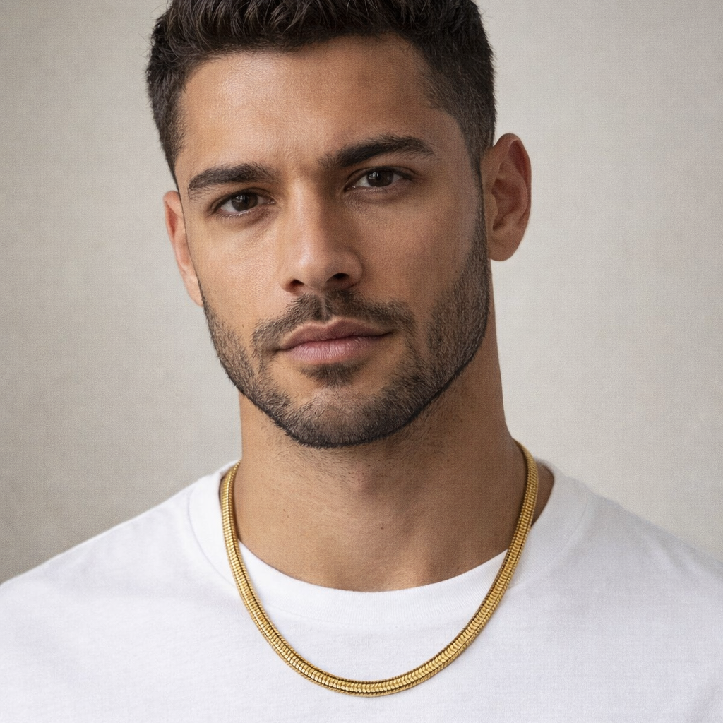 Man wearing a gold chain necklace against a neutral background