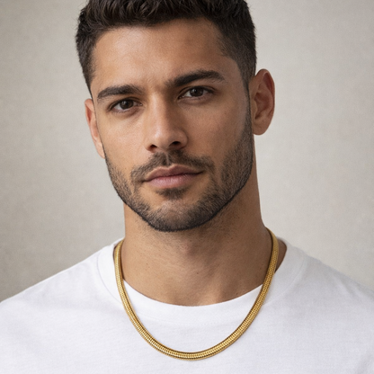 Man wearing a gold chain necklace against a neutral background