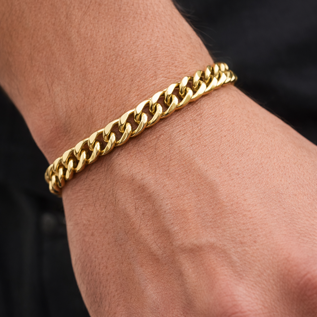 Gold chain bracelet on a wrist with a black background