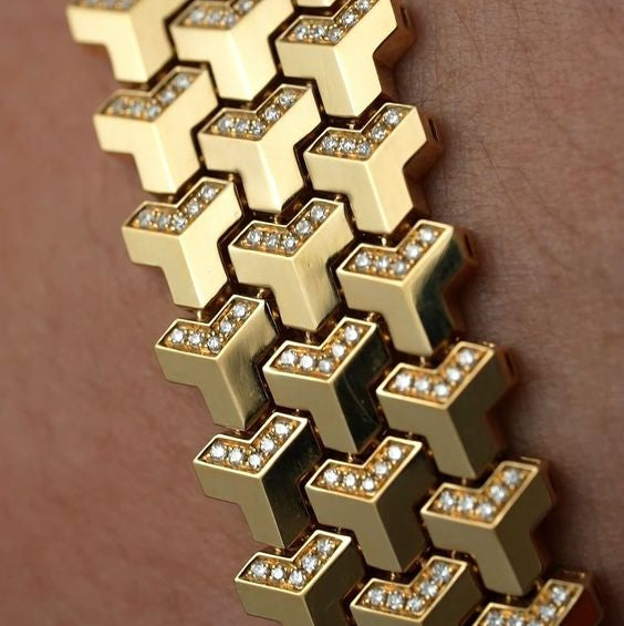 Gold bracelet with diamond accents on a skin-toned surface