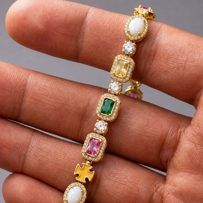 Gold bracelet with colorful gemstones on a hand against a gray background