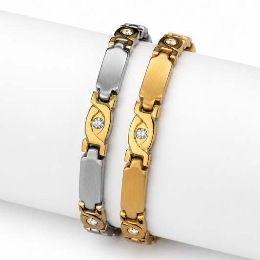 Two metal bracelets displayed on a white cylindrical wrist form. One bracelet is silver-toned with elongated rectangular links and small clear stones.