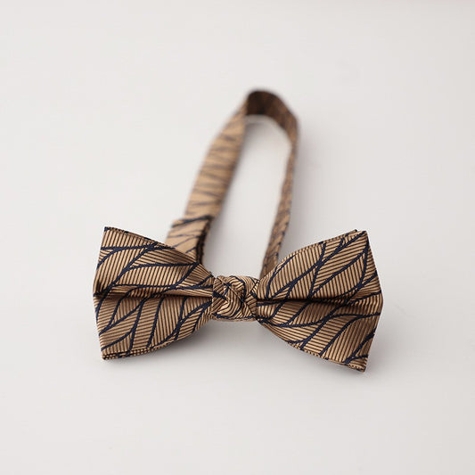 A stylish bow tie and a small wooden bowl are placed on a table, highlighting a unique combination of sophistication and simplicity.