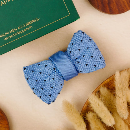 A blue bow tie elegantly placed on a polished wooden table, showcasing its vibrant color and texture.
