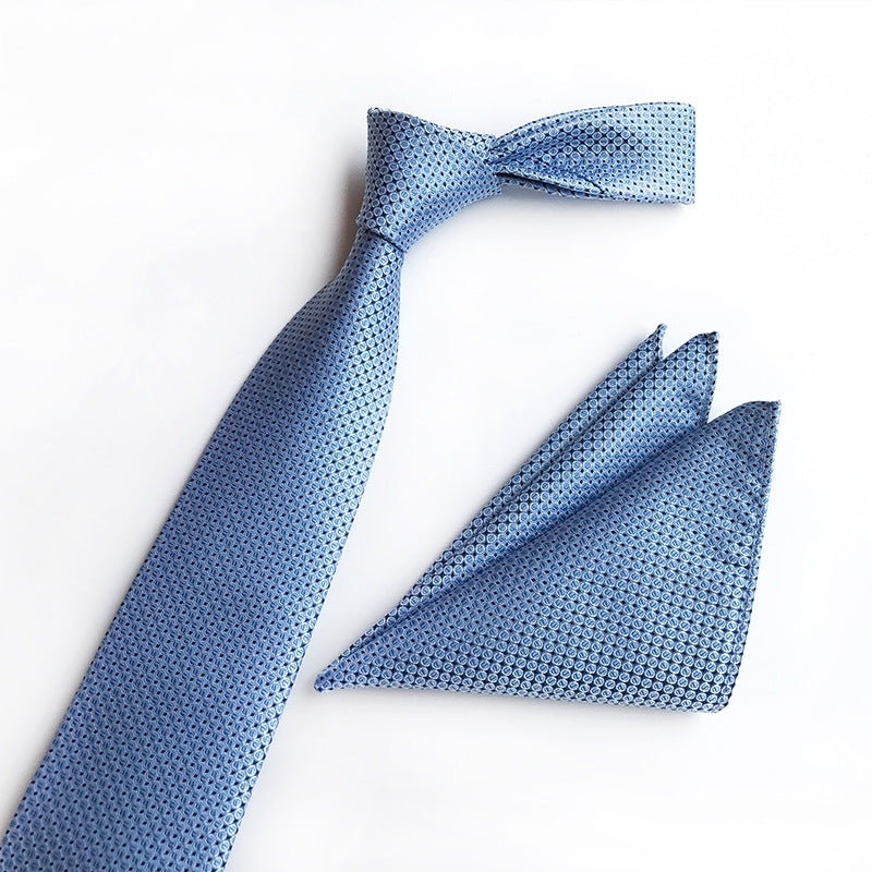  A blue tie and matching pocket square elegantly displayed on a pristine white surface.