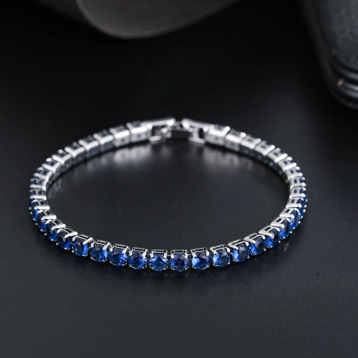 Silver bracelet with blue stones on a dark background