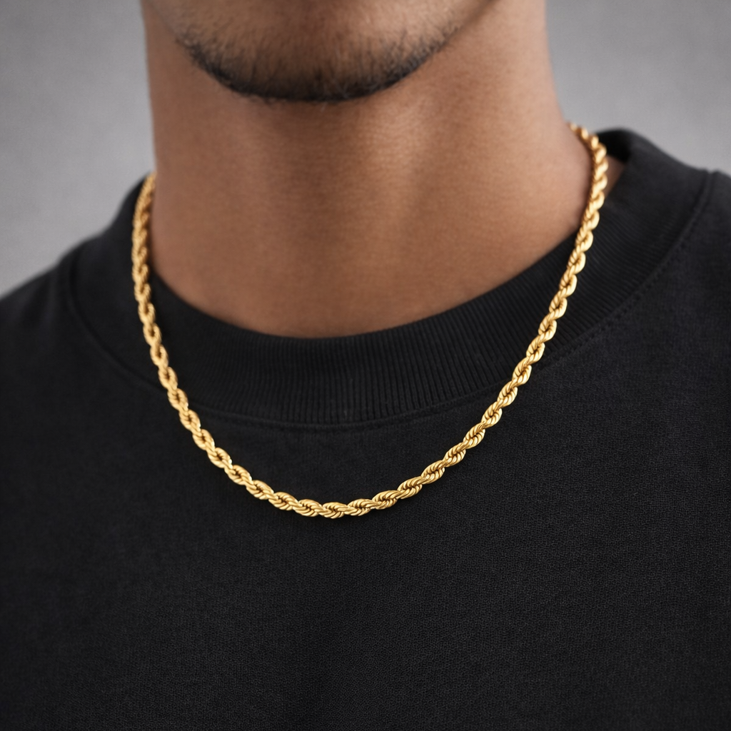 Gold chain necklace worn by a person on a black background