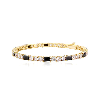 Gold bracelet with black and clear stones on a white background