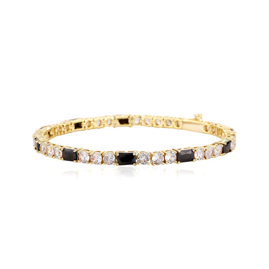 Gold bracelet with black and clear stones on a white background