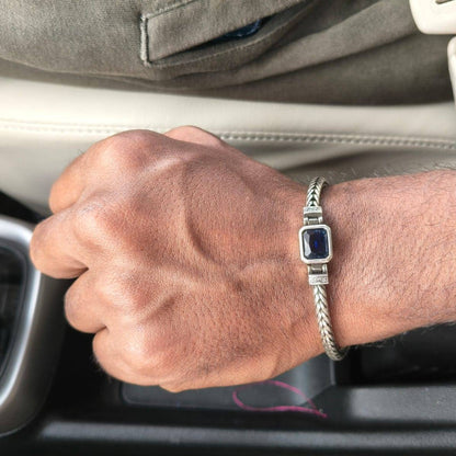 Hand with a bracelet on a car dashboard