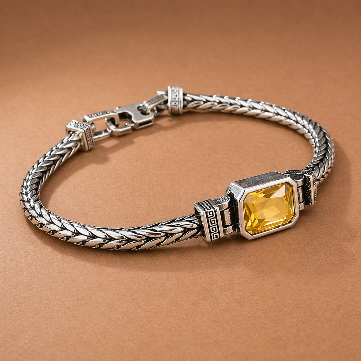 Silver bracelet with a yellow gemstone on a brown background