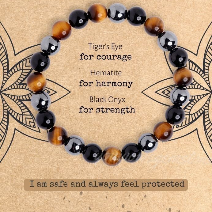 Bracelet with tiger's eye, hematite, and black onyx beads on a decorative background.