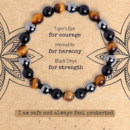 Bracelet with tiger's eye, hematite, and black onyx beads on a decorative background.